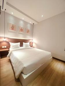 巴淡岛中心Oxy suites 2-02 at Shop House Meisterstadt Pollux Habibie的一间卧室配有一张带白色床单的大床