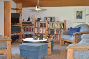 希格斯多夫AlpenGlück – **** Ferienwohnung的客厅配有咖啡桌和书架