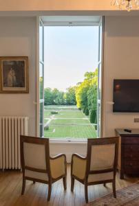 奥利韦Château du Rondon的客厅设有大窗户,享有网球场的景色