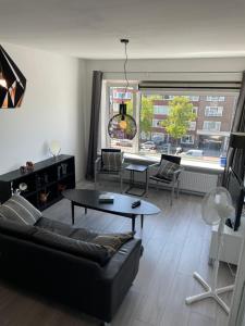 鹿特丹Sunny and spacious apartment的客厅配有沙发和桌子
