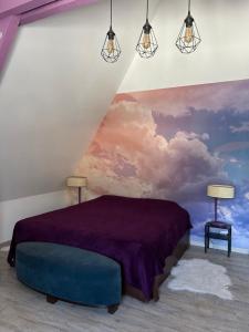 达克斯Le Montmieri的一间卧室配有紫色的床,墙上挂着一幅画