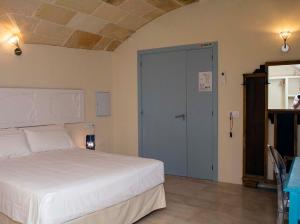 休达德亚Boutique Hotel RifugioAzul的卧室配有白色的床和蓝色的门