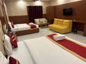 AyodhyaRoyal Heritage Hotel & Resort的酒店客房设有两张床和电视。