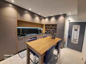 凯撒利亚Sea View Suites - דירות נופש עם מקלט的一间带木桌和蓝色椅子的用餐室