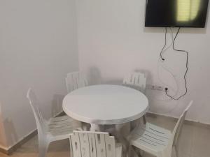 胡塞马Un appartement à proximité de la corniche Hoceima pour les familles的带电视的客房内的白色桌椅