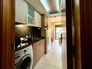 朱尼耶哈亚里套房公寓式酒店的厨房配有洗衣机和水槽