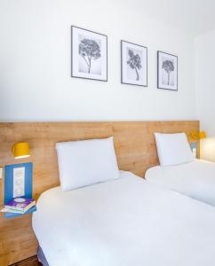 热姆诺Kyriad Marseille Est Aubagne Gémenos的配有白色床单的客房内的两张床
