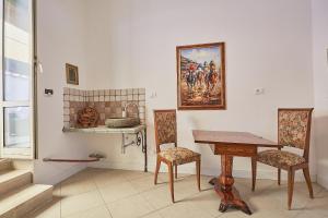 布拉恰诺LE CAMERE di VITTORIA的一间设有桌椅和壁画的房间