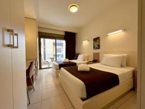 朱尼耶哈亚里套房公寓式酒店的酒店客房设有两张床和一个阳台。