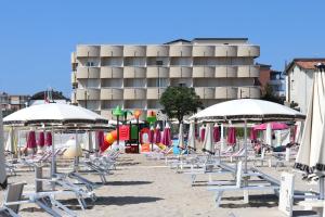里米尼Hotel Graziella的沙滩上的一把椅子和遮阳伞