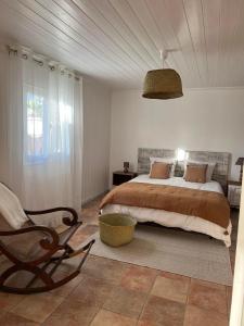 勒唐蓬Le vieux poirier à la Plaine des Cafres的一间卧室配有一张大床和一把椅子