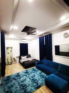 瓜拉丁加奴MINI HOTEL CONCEPT的客厅配有蓝色的沙发和床。
