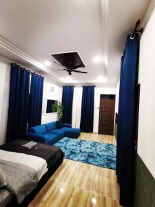 瓜拉丁加奴MINI HOTEL CONCEPT的客厅配有床和蓝色沙发