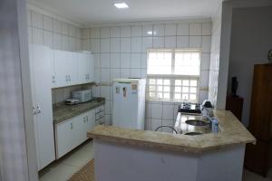 库亚巴Pousada dos Bosques - Refúgio Urbano的厨房配有水槽和白色冰箱