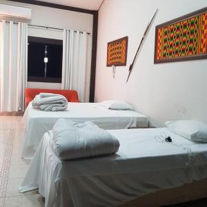 库亚巴Pousada dos Bosques - Refúgio Urbano的客房设有两张床和窗户。