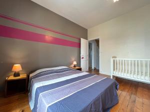 勒芒Le Roadtrip- Maison - Jardin - Tramway - 8p的一间卧室配有一张床和条纹墙