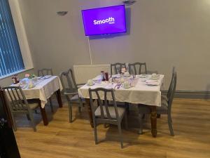 布莱克浦Bradburys of Blackpool的一间配备有桌椅和紫色屏幕的用餐室