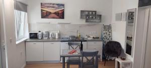 拉布Studio Apartman Tariba的厨房配有白色橱柜和桌子