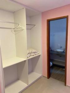 圣阿马鲁CasAMAR lençóis的带白色架子的房间和带水槽的浴室