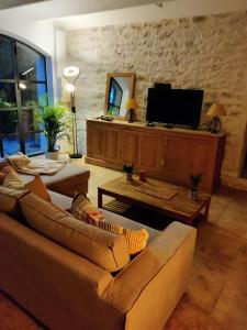 Boisset-et-GaujacGite au sein d'un Mas Provençal的客厅配有2张沙发和1台平面电视