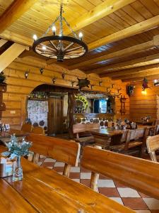KuczówKarczma u Jana的餐厅设有木桌、长凳和吊灯。