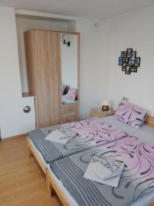德辛apartman.lara的一间卧室配有一张带紫色床单和镜子的床