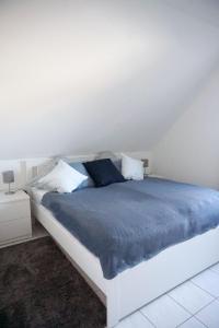 卡罗利嫩西尔Ferienwohnung Mühlenblick 3的卧室内的一张白色床和蓝色床单