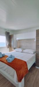 克罗诺维察Mobile home Greta的一间卧室配有两张带毛巾的床