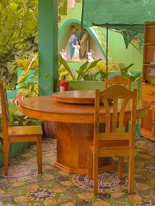 BatuanBARRIL GREEN HOMESTAY的一张带两把椅子的木桌和一幅画架