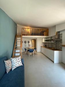 波尔图Casas da Corujeira的一间带蓝色沙发的客厅和一间厨房