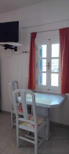 MaltezanaFilina's Studio的厨房配有桌子和两把椅子,设有窗户。