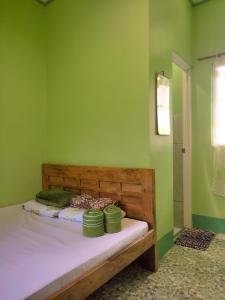 BatuanBARRIL GREEN HOMESTAY的一间卧室设有一张带绿色墙壁的床