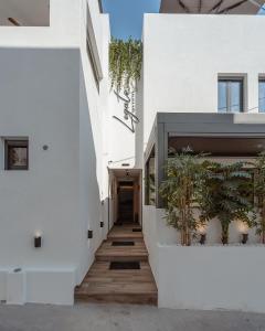 纳克索乔拉Legato Spa Suites的白色建筑的走廊,有植物