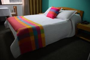 杜伊塔马HOTEL SUAREL CENTER的床上有色彩缤纷的毯子和枕头