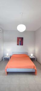 MaltezanaFilina's Studio的一间卧室配有一张带两张桌子的大型橙色床