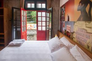 里约热内卢Lobie Armazém São Joaquim的卧室配有白色的床和红色的门