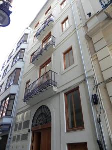 瓦伦西亚Catalina Suites Apartments Downtown Valencia的白色的建筑,设有窗户和阳台