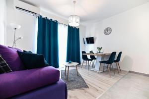 比比涅Apartments MENA的客厅配有紫色沙发和桌子