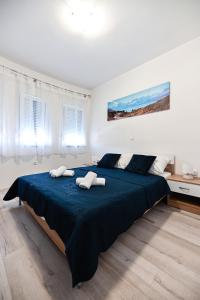 比比涅Apartments MENA的一间卧室配有一张大床和两条毛巾