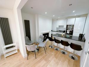 伦敦Massive Flat Near Greenwich Park( with office)的厨房配有玻璃桌和椅子
