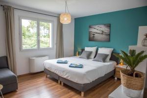 卡布勒通Ocean Garden Surf Lodge的一间卧室设有一张大床和蓝色的墙壁