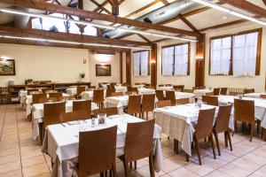 巴加卡阿马伽酒店的一间设有白色桌椅的用餐室