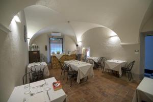 加维Palazzo Sertorio Suites的一间带桌椅的餐厅和一间厨房内的厨师