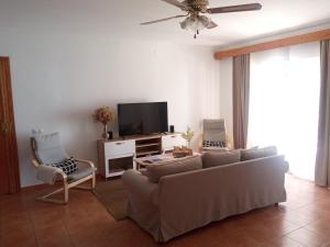 乌特雷拉Casa Rural El Algarrobo的带沙发和平面电视的客厅