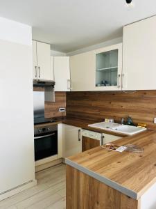 帕拉瓦莱弗洛RAINIE APPART的厨房配有白色橱柜和木制台面