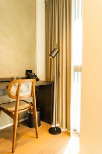 瓦勒海姆Parkhotel Waregem的一张桌子,椅子和一盏灯放在房间里