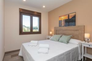 塔皮亚德卡萨列戈Hacienda El Esteiro - Villas vacacionales的卧室设有一张白色大床和两个窗户。