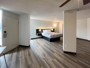 纳科多奇斯Studio 6 Nacogdoches TX SFA University的铺有木地板的客房内设有一间卧室和一张床。