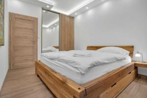阿贝尔塔米SKI Apartmán Snowcat的一间卧室配有一张大床和大镜子