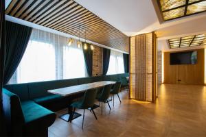 坎普朗莫道尼斯Berghaus Bucovina的一间带桌子和绿色椅子的用餐室